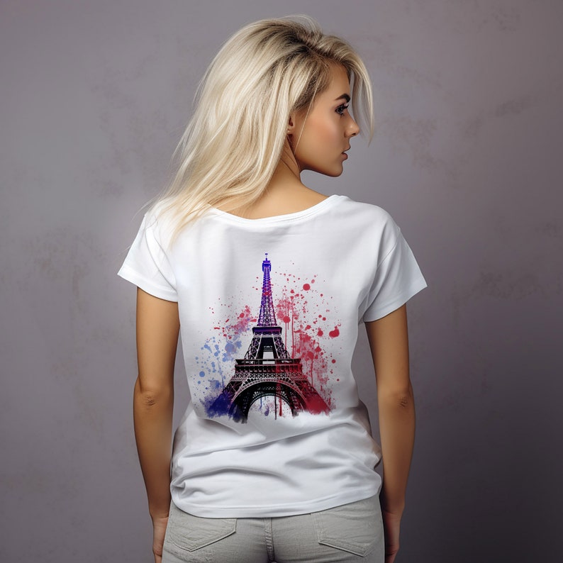 Op de afbeelding: Wit T-shirt met een zwart-wit afbeelding van de Eiffeltoren met blauwe en rode verfspatten op de achterkant.