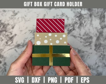 May include: A stack of three gift boxes, each with a different pattern. The top box is red with white stripes, the middle box is beige with white polka dots, and the bottom box is green with a gold ribbon. The boxes are being held in a person's hands.
