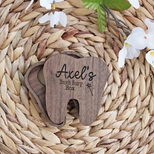 May include: A wooden tooth fairy box shaped like a tooth with the name "Axel's" and the words "Tooth Fairy Box" engraved on it.