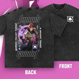 May include: Dark gray t-shirt featuring a graphic of a character with red hair and a brown coat, with the text "Gambit" and "a winning hand!" on the back. The front displays a white spade symbol. The shirt has a vintage, washed look.