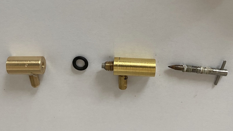 May include: Three brass fittings with a black o-ring. The fittings have a threaded end and a side outlet. The third fitting is a metal rod with a pointed end.