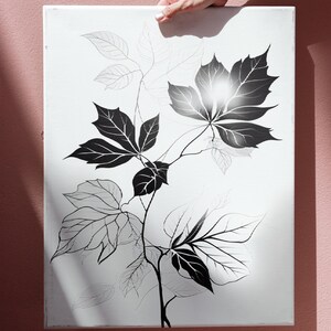 May include: A black and white canvas print featuring a stylized illustration of leaves and branches.