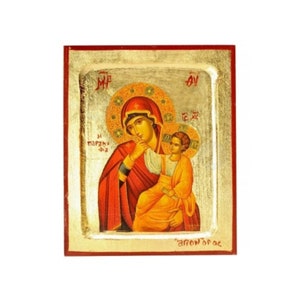 Può includere: Un'icona dipinta a mano della Vergine Maria e del bambino Gesù. L'icona è su un pannello di legno con sfondo dorato e bordo rosso. La Vergine Maria indossa una veste rossa e un mantello blu. Tiene il bambino Gesù tra le braccia. Il bambino Gesù indossa una veste gialla. L'icona è intitolata "La Vergine Maria" in greco.