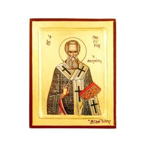 Op de afbeelding: Een handgeschilderd icoon van Sint Gregorius de Theoloog, een prominente figuur in de oosters-orthodoxe kerk. Het icoon toont een gedetailleerde afbeelding van de heilige in traditionele kleding, die een boek en een kruis vasthoudt. De achtergrond is in een warme gouden kleur, en het icoon is ingelijst in een eenvoudig houten frame.