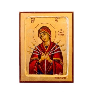 May include: A religious icon depicting the Virgin Mary with seven swords piercing her heart. The icon is painted in a traditional style with gold accents and a wooden frame. The text "MH","OY", "'H επτα σπαθη", and "αγιος'ορος" is visible on the icon.