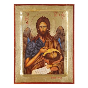 Puede incluir: Un icono pintado a mano de Juan el Bautista sosteniendo la cabeza de Juan el Bautista. El icono está sobre un fondo dorado con un marco rojo. El texto en el icono dice "Ιω ο προδρόμος" que en griego significa "Juan el Precursor".