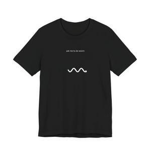May include: Black t-shirt with the text "ask me to do worm" above a white squiggly line. The shirt is a basic crew neck style, suitable for casual wear.