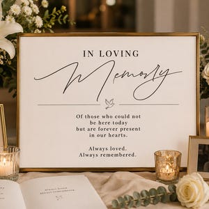 May include: A rectangular sign with a gold frame featuring the black text IN LOVING MEMORY, a small dove icon, and the message: Of those who could not be here today but are forever present in our hearts. Always loved. Always remembered.