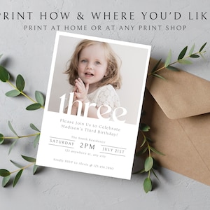 Op de afbeelding: Een witte en grijze verjaardagsuitnodiging met een foto van een jong meisje. De uitnodiging zegt "three" in grote witte letters en bevat de tekst "Please Join Us to Celebrate Madison's Third Birthday!" De uitnodiging bevat ook de datum en tijd van het feest.