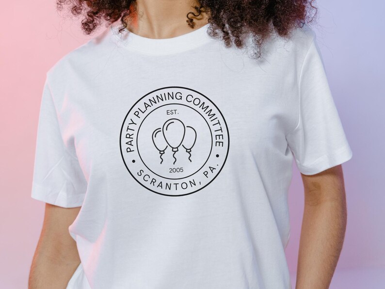 May include: White t-shirt with a black and white logo that says "Party Planning Committee Est. 2005 Scranton, PA."