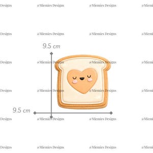 Peut inclure: Un biscuit en forme de pain avec un cœur en beurre de cacahuète. Le biscuit mesure 9,5 cm de haut et de large. Le cœur en beurre de cacahuète a un visage souriant. Le texte "MDC 030" est visible.