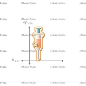 May include: A syringe-shaped cookie cutter with a light orange filling and a green plunger. The cutter is 4 cm wide and 10 cm tall, decorated with small pink flowers. The text "MDC 045" is in the upper right corner.