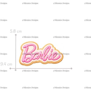 Op de afbeelding: Een roze en wit Barbie-logo, 9,4 cm breed en 5,8 cm hoog, met een lichtbruine rand. De tekst "Barbie" is in een cursief lettertype. De afbeelding bevat ook de tekst "MDC 010".
