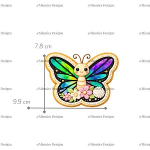 Pode incluir: Um design de borboleta colorido, 9,9 cm x 7,8 cm, com um rosto fofo e detalhes florais. As asas apresentam um gradiente de arco-íris. O design é delineado em dourado e inclui o texto "MDC 026".