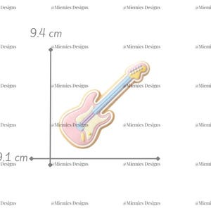 May include: A pink and blue electric guitar-shaped cookie cutter. The guitar measures 9.1 cm by 9.4 cm. The text "MDC 187" is in the upper right corner. The cookie cutter is on a white background.