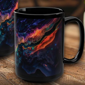 Op de afbeelding: Twee zwarte keramische mokken met een levendig, abstract ontwerp in tinten blauw, paars, oranje en groen. De mokken zijn cilindrisch met een handvat. De tekst "Printed Mug" en "HappyWKNDClub" staat onderaan.