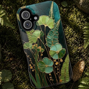 May include: A rectangular smartphone case featuring a dark teal background with a botanical illustration of green ferns and rounded leaves outlined in gold. The design includes small gold circular accents and a black camera cutout at the top left.