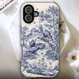 Op de afbeelding: Een telefoonhoesje met een blauw en wit toile de Jouy-ontwerp met kikkers die instrumenten bespelen in een bosscène. De hoes is compatibel met MagSafe en heeft de tekst "Premium Flat Printed Phone Cases".