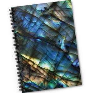 May include: A spiral-bound notepad with a flat printed cover. The cover displays a close-up of a gemstone with blue, green, and yellow hues. The notepad has a black spiral binding and the text "Flat Printed Notepad".