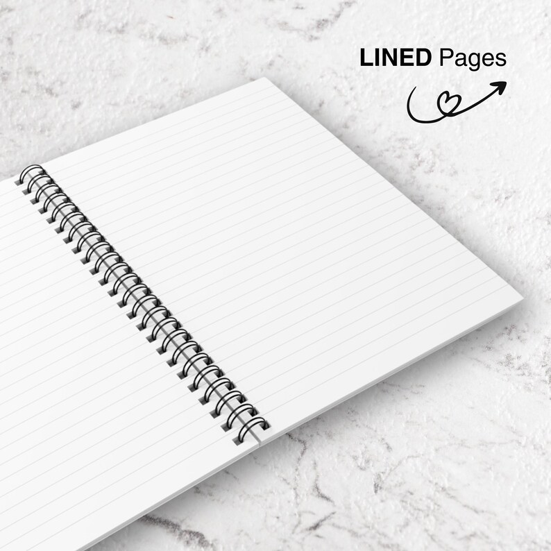 May include: Open spiral notebook with lined pages. The notebook is open to reveal the white pages with horizontal lines. The binding is a black metal spiral. The words "LINED Pages" are printed in black, with a heart and arrow graphic.