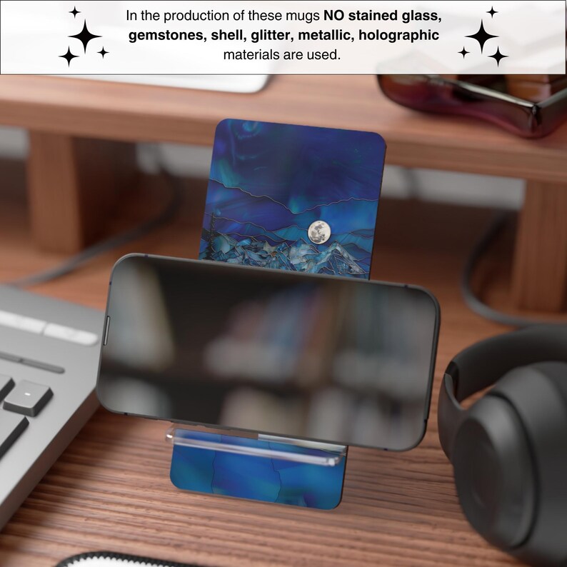May include: A smartphone rests on a blue and white patterned phone stand. The stand and the background feature a design with a moon and mountain scene. The text in the image states that no stained glass, gemstones, shell, glitter, metallic, or holographic materials are used.