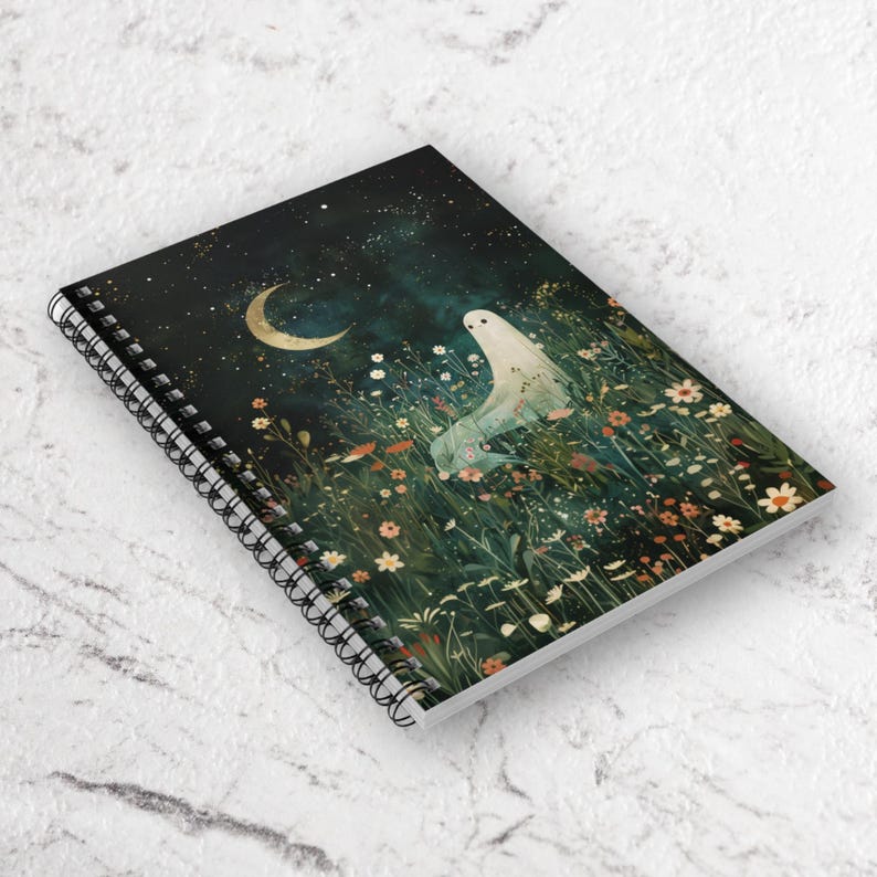 May include: Spiral-bound notebook featuring a whimsical illustration. The cover depicts a serene night scene with a crescent moon, stars, and a ghostly figure in a field of wildflowers. The color palette includes dark blues, greens, and touches of gold.