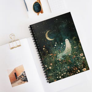 May include: Spiral-bound notebook featuring a whimsical illustration of a ghost in a field of wildflowers under a crescent moon and starry night sky. The cover art is predominantly dark green and black, with accents of gold, white, and various floral colors.