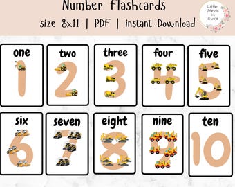 May include: Ten printable flashcards featuring the numbers 1 through 10 in a peach color with a black outline. Each number has a different number of yellow construction vehicles around it.