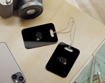 May include: Two black luggage tags with white text and a gold airplane icon. The text on the tags reads "You can always make more money, but you can't make more time".