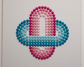 May include: Abstract artwork with a central, rounded design made from small, coloured spheres. The spheres change colour from pink to blue, creating a gradient effect. The artwork is set against a white background.
