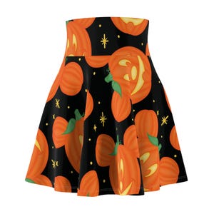 Puede incluir: Falda skater negra con un estampado repetido de calabazas naranjas con tallos verdes y caras amarillas brillantes. Las calabazas están sobre un fondo negro con acentos de estrellas amarillas. Una falda con temática de Halloween.