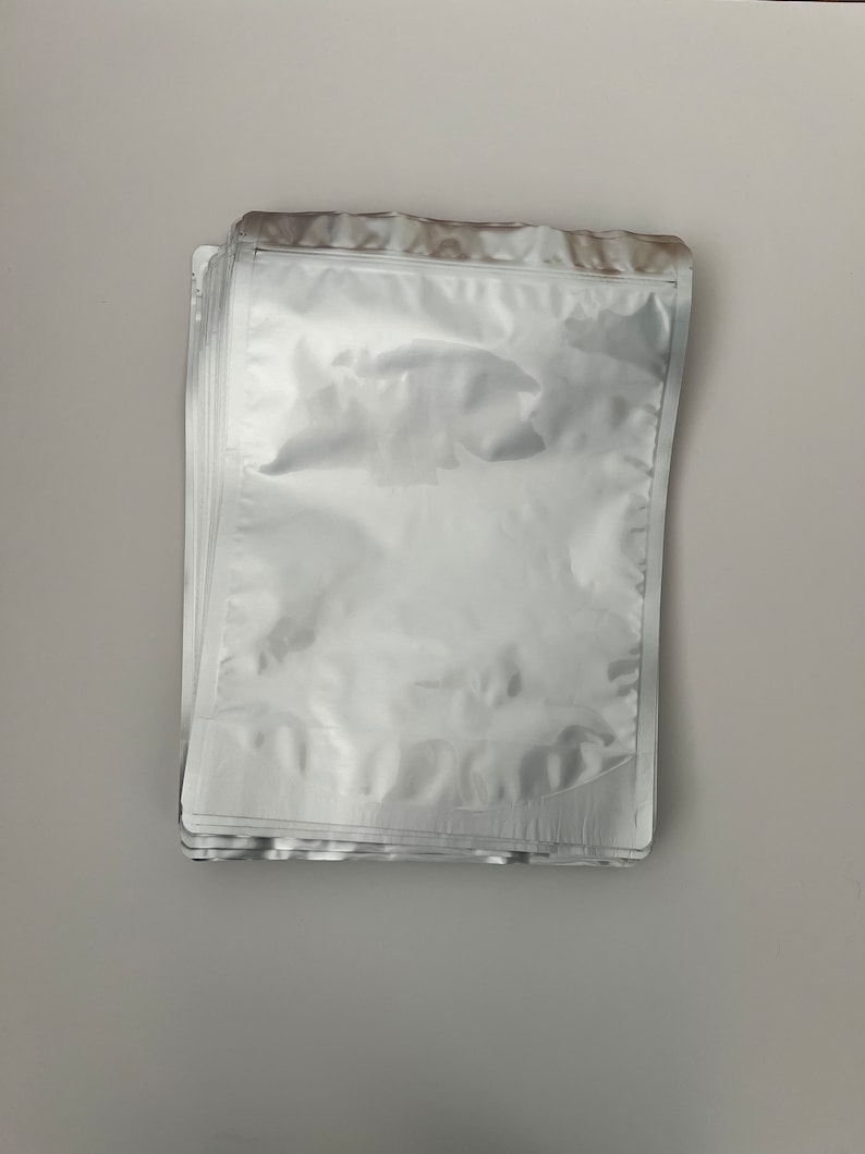 May include: A stack of clear, silver, and white plastic resealable bags with a zipper closure.