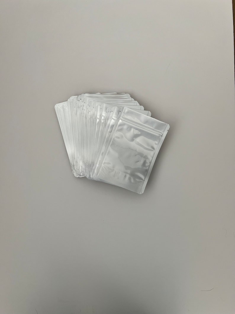 May include: A stack of white plastic resealable bags with a zipper closure.