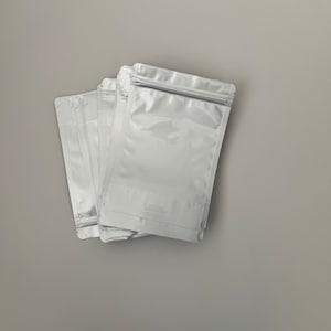 May include: A stack of five white plastic resealable bags with a zipper closure.