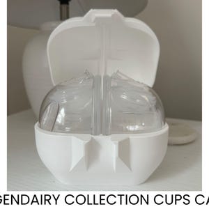 May include: A white, egg-shaped case with a hinged lid, open to reveal clear, rounded containers. The case is labeled "LEGENDARY COLLECTION CUPS CASE" in black text at the bottom. The case is sitting on a white surface.