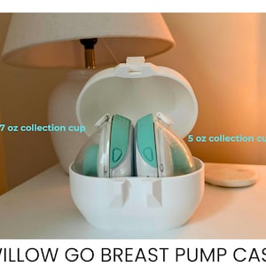 May include: White breast pump case with two collection cups. The case is open, revealing two breast pumps with teal accents. The text on the image reads "7 oz collection cup" and "5 oz collection cup". The text at the bottom reads "WILLOW GO BREAST PUMP CASE".