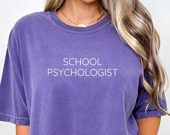 May include: A purple oversized t-shirt with the text "SCHOOL PSYCHOLOGIST" printed in white on the front.