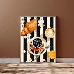 Breakfast Kitchen Wall Art featuring a stack of blueberry pancakes, a golden croissant, latte with heart-shaped foam art, fresh orange juice, and white blossoms arranged over a bold black and cream striped background. Modern food illustration with warm colors and contemporary design. This kitchen wall decor is perfect for coffee bars, breakfast nooks, dining rooms, cafes, brunch-inspired spaces, and stylish modern home interiors.
