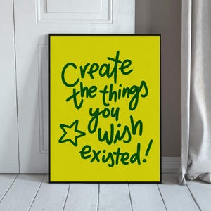 Peut inclure: Une affiche murale rectangulaire avec un fond jaune vif et un texte manuscrit vert foncé qui dit Create the things you wish existed! accompagné d'une petite étoile dessinée à la main située à gauche des dernières lignes de texte.