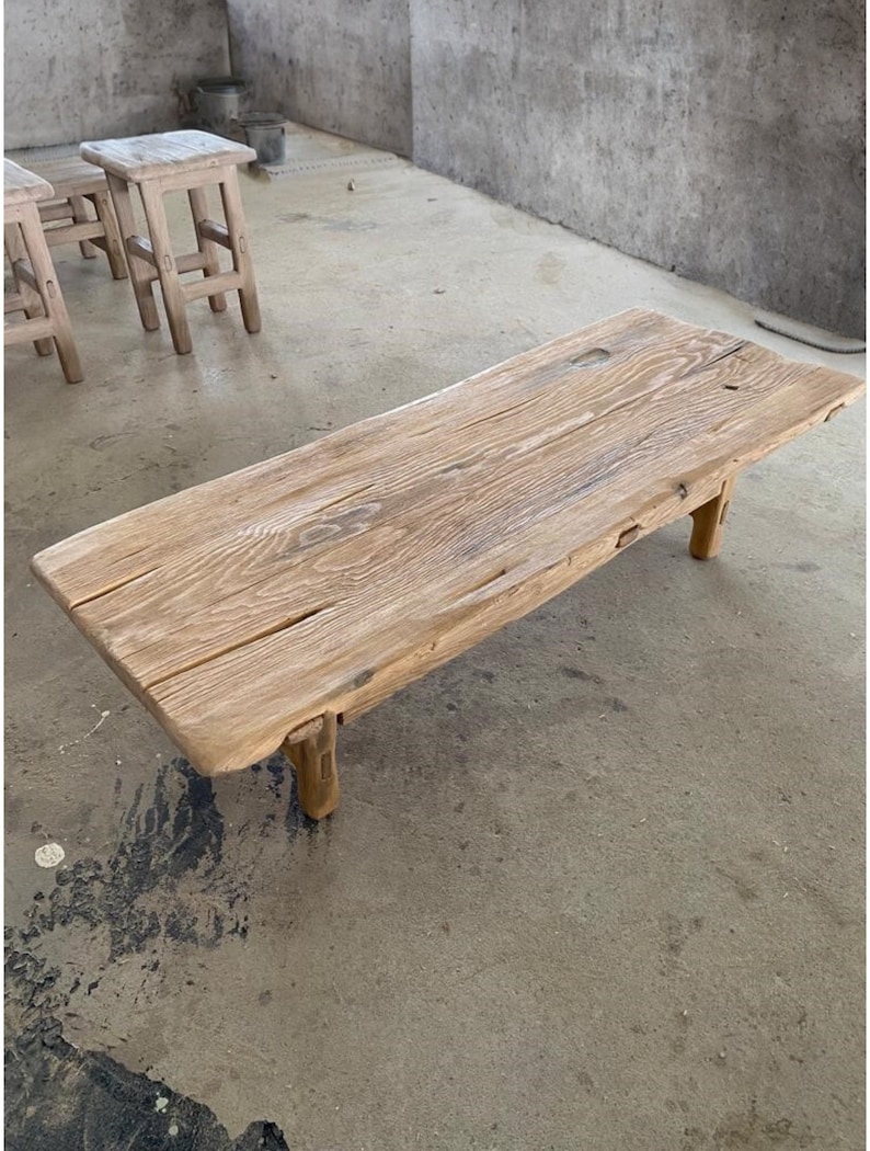 May include: A rectangular, light-colored wooden coffee table with visible wood grain and four short legs. The table is approximately 60 inches long. The design is rustic and natural, with a focus on the wood's texture and color.