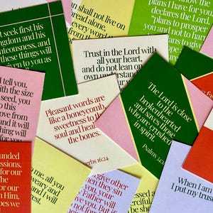 May include: A collection of colorful cards with inspirational quotes and Bible verses. The cards are in various colors, including green, pink, yellow, and red, with white text. The cards are arranged in a scattered pattern.
