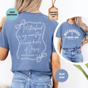 May include: A blue t-shirt with white text that reads "Motherhood is my ministry Raising disciples of Jesus Proverbs 22:6". The shirt is shown on a model wearing blue jeans.