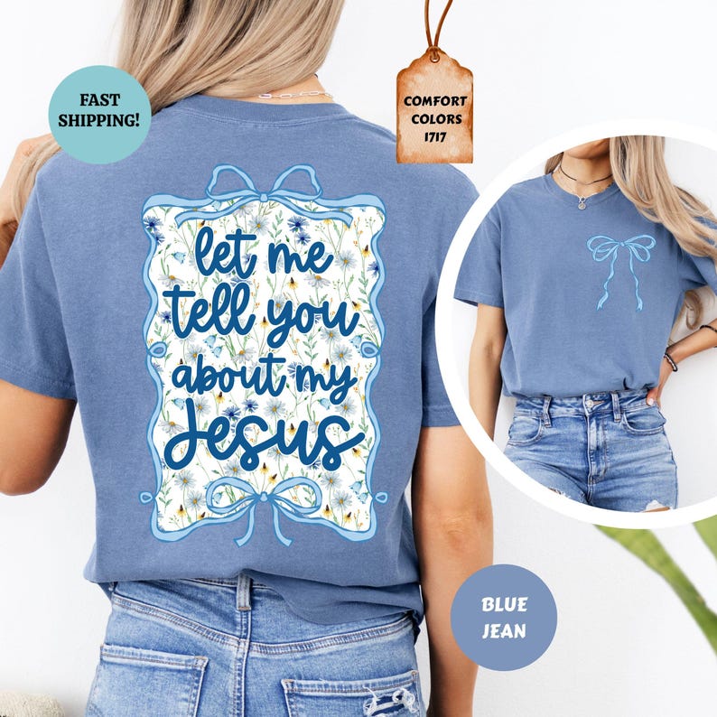 May include: Blue jean-colored t-shirt with the text "let me tell you about my Jesus" in a decorative floral frame. The shirt has a bow design on the front and back. The shirt is a Comfort Colors 1717.