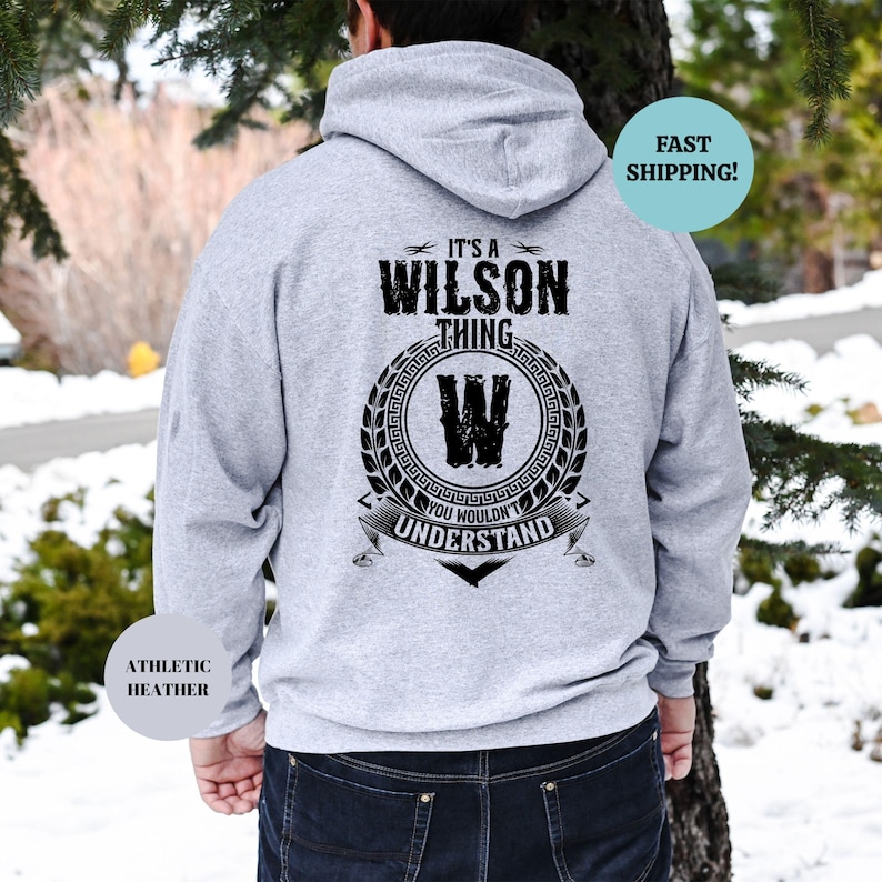 May include: A gray hooded sweatshirt with the text "It's a Wilson thing" and a black and white graphic of a "W" inside a wreath. The text "You wouldn't understand" is below the graphic.