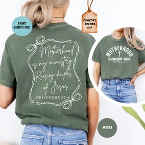 May include: Green t-shirt with white text that reads "Motherhood is my ministry Raising disciples of Jesus Proverbs 22:6". The shirt is shown on a model wearing blue jeans. A second image shows a green t-shirt with white text that reads "Motherhood is Kingdom work Proverbs 12:6".