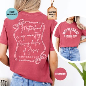 May include: A red t-shirt with a white design that says "Motherhood is my ministry Raising disciples of Jesus Proverbs 22:6". The back of the shirt has a white cross and the text "Motherhood is Kingdom Work Proverbs 12:6".
