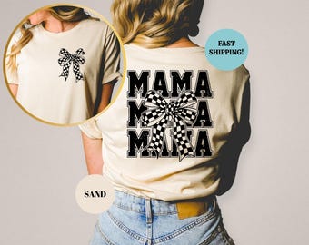 Op de afbeelding: Een zandkleurig T-shirt met de tekst "Mama Mama Mama" in zwart met een zwart-wit geblokte strik in het midden.