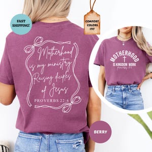 May include: Two purple t-shirts with white text. The first shirt says "Motherhood is my ministry Raising disciples of Jesus Proverbs 22:6". The second shirt says "Motherhood is Kingdom Work Proverbs 22:6".