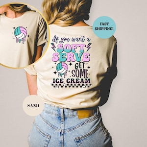 Könnte beinhalten: Sandfarbenes T-Shirt mit einem Volleyball-Grafik auf der Vorder- und Rückseite. Die vordere Grafik zeigt einen Volleyball mit tropfenden Details. Auf der Rückseite des Shirts steht der Text "If you want a soft serve get some ice cream."