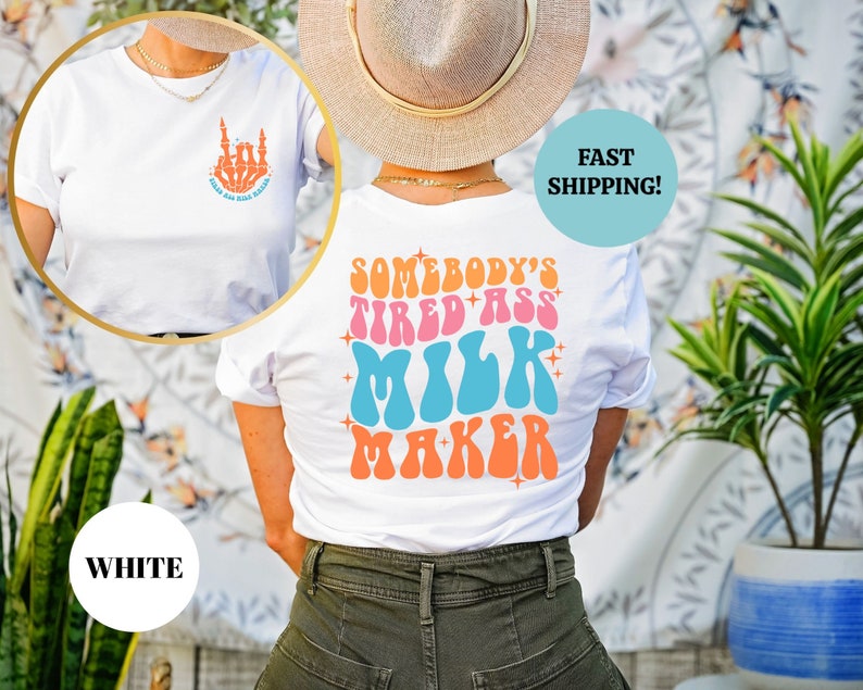 Pu&ograve; includere: Maglietta bianca con una grafica sul retro che dice "Somebody's Tired Ass Milk Maker" in un font retr&ograve; con colori rosa, blu e arancio. La parte anteriore della maglietta ha un piccolo grafico di una mano con il dito medio esteso.